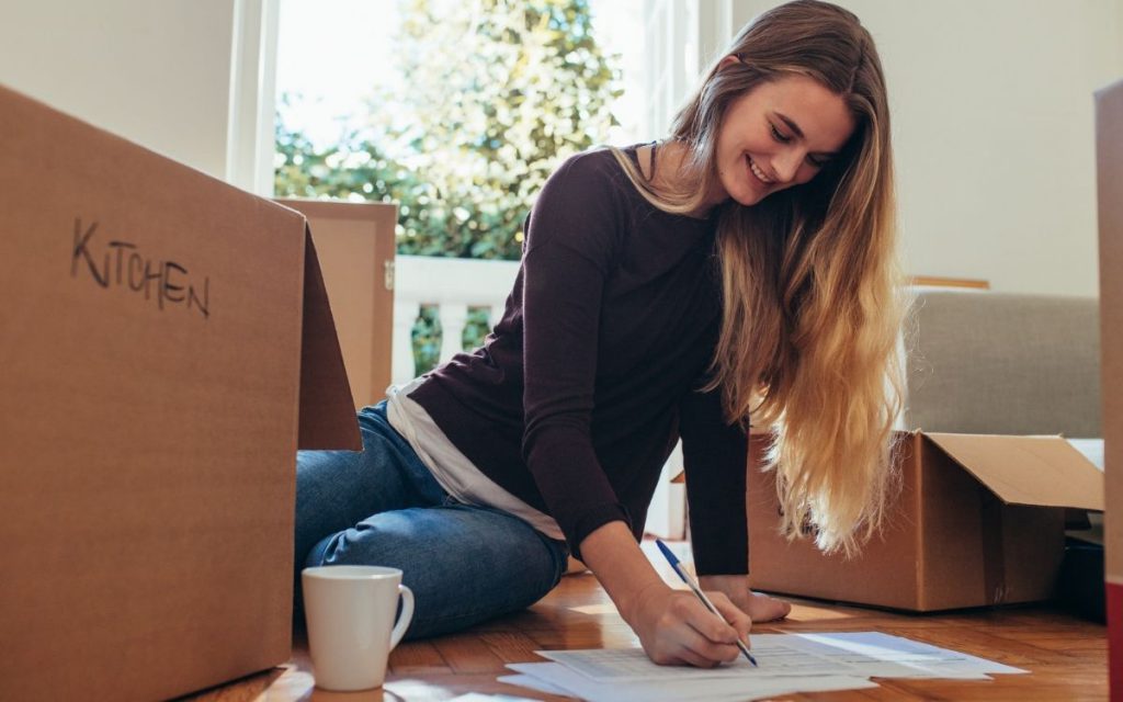 woman packing boxes and making a list